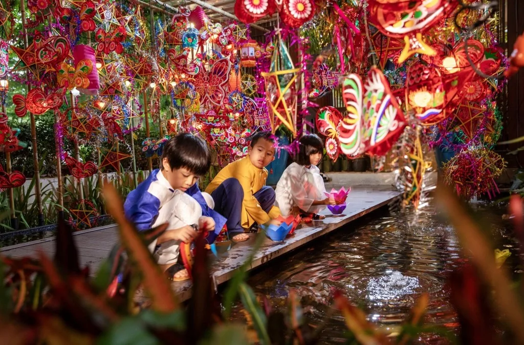 Các em nhỏ trong trang phục truyền thống vui rước đèn, thả hoa đăng bên hồ nước rực rỡ lồng đèn giấy kiếng